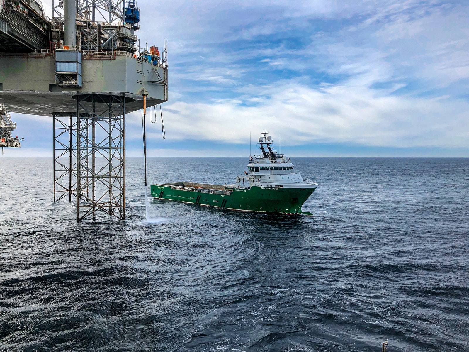 Green and White Ship on Sea Under Blue Sky