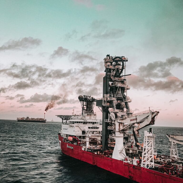 red and white ship on sea under cloudy sky during daytime